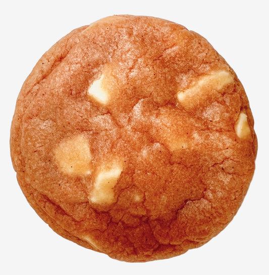 Round pink cookie with white chocolate chips on a light background