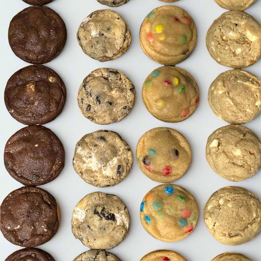 Assorted cookies including chocolate, sugar, and M&M cookies on a cooling rack.