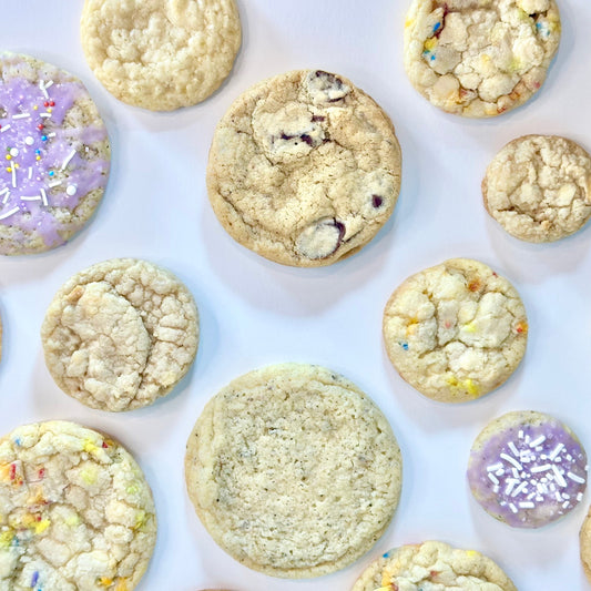 Assorted cookies with different toppings on a white surface